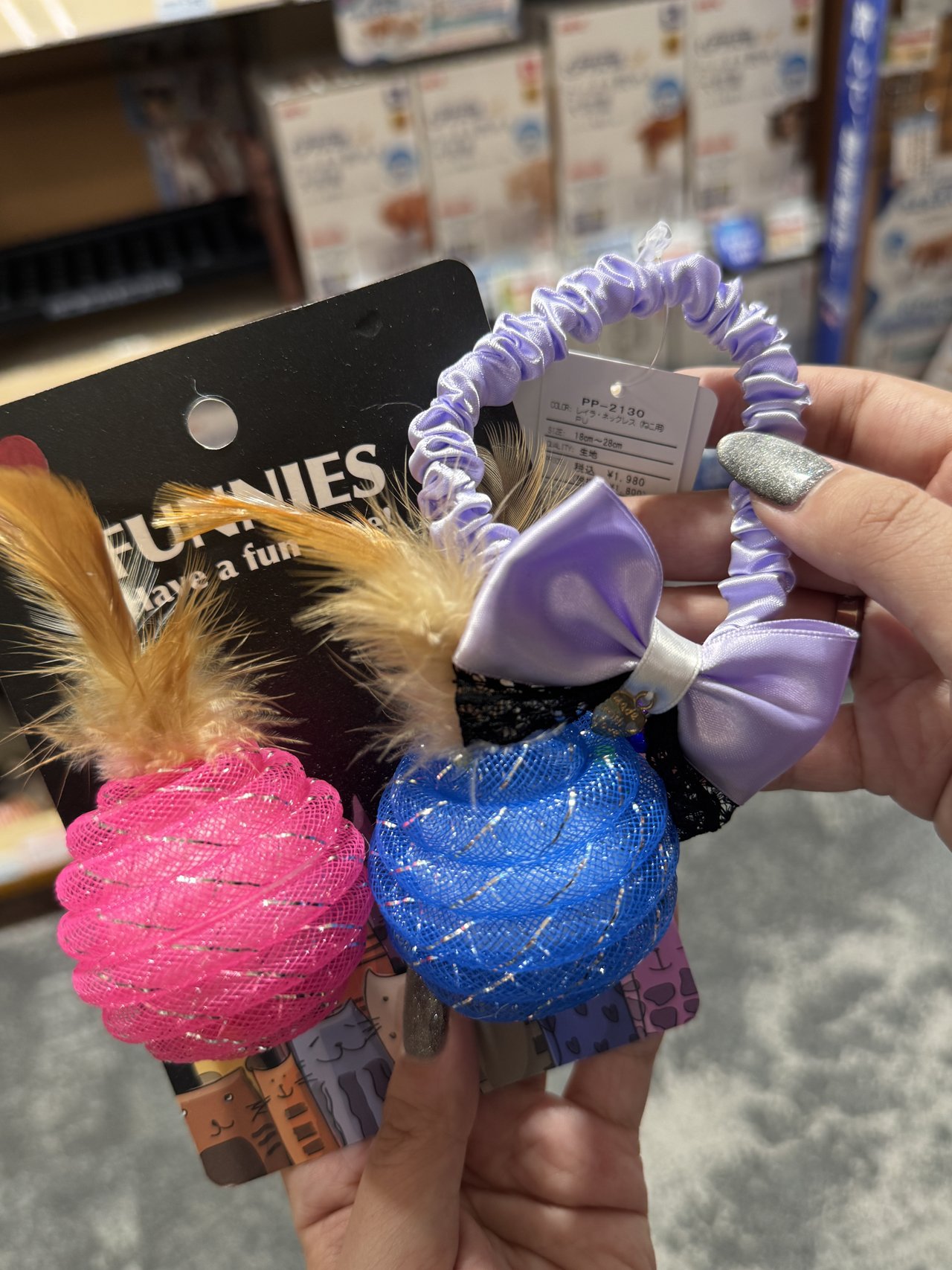 FUNNIESの台紙に付いたピンクと青の羽根付きボールと、値札の付いた猫用ネックレス