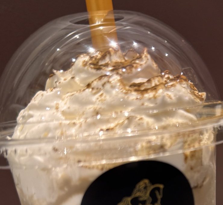 ショコリキサーのホイップを近くから撮った写真。白いホイップに茶色の粉がかかり、ふたの中に盛られている