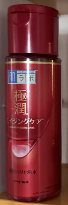 肌ラボ 極潤 エイジングケアの赤いボトル。下の方に薬用ハリ化粧水とロート製薬の文字