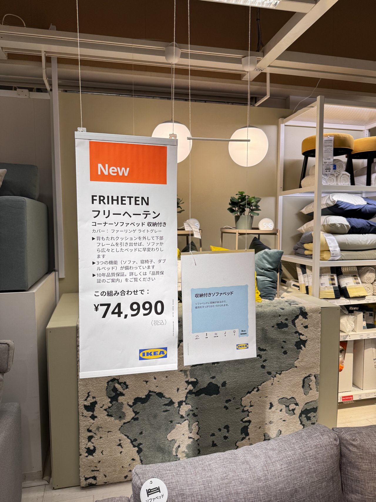 IKEAの売り場の吊り看板。New・FRIHETEN フリーヘーテン コーナーソファベッド 収納付き・74,990円（税込）と書かれている
