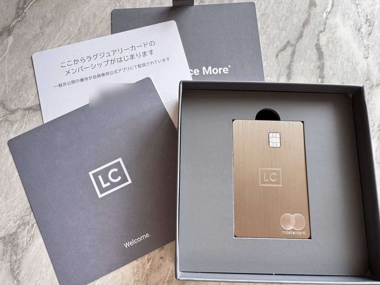 箱を開けたところ。グレーの台紙に収まったカードと、Welcomeのカード・メンバーシップの案内・冊子