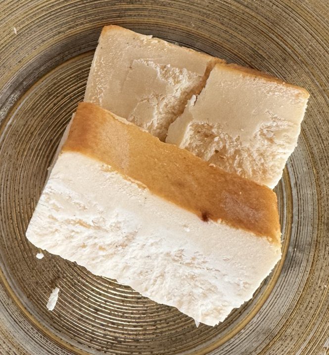 ミスターチーズケーキの断面。上の面に焼き色があり、下はクリーム色