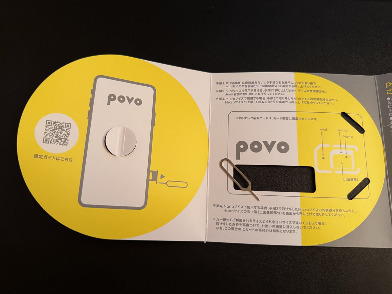 povo のSIMカードの台紙を開いたところ。左にスマホの絵と設定ガイドのQRコード、右にSIMピンと取り外しの手順