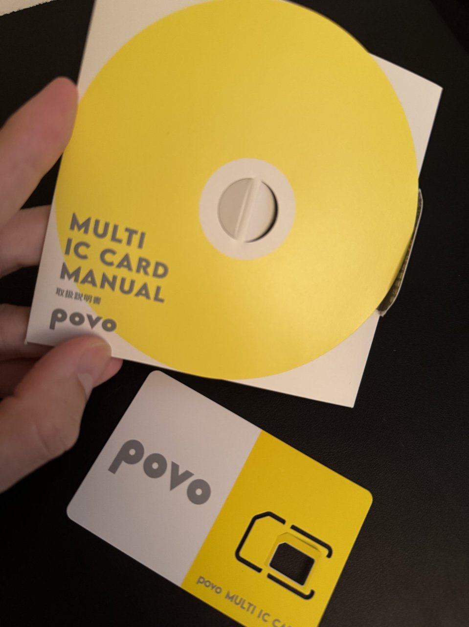 povo のSIMカードの取扱説明書。黄色い丸い台紙にMULTI IC CARD MANUALと書かれ、下に白と黄色のカードがある