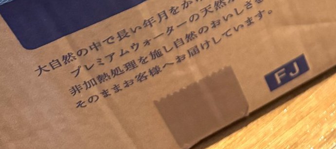 段ボールに印刷された非加熱処理の天然水の説明文とFJの表示