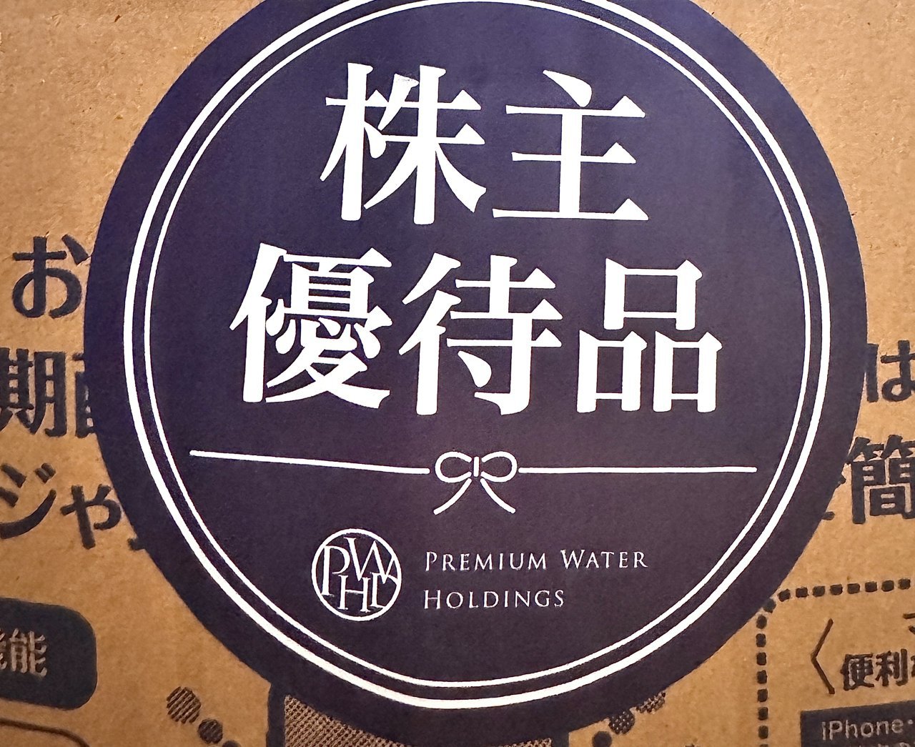 紺色の丸いシールに株主優待品の文字とリボンの絵とPREMIUM WATER HOLDINGSのロゴ
