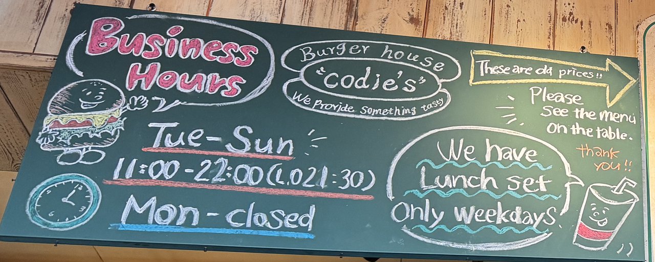 営業時間の黒板。Tue-Sun 11:00-22:00、Mon closed、平日だけのランチセットの案内