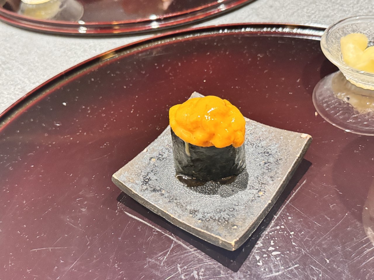 黒い角皿にのったウニの軍艦