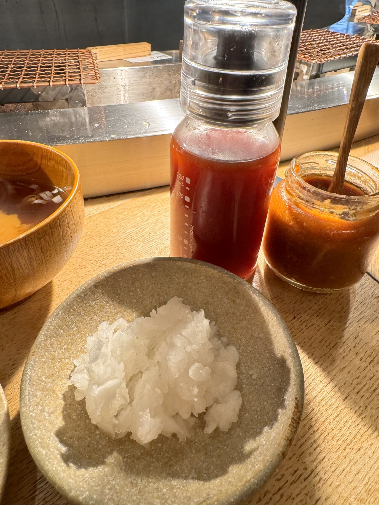 大根おろし・ポン酢の瓶・赤い薬味の入った小瓶と味噌汁の椀