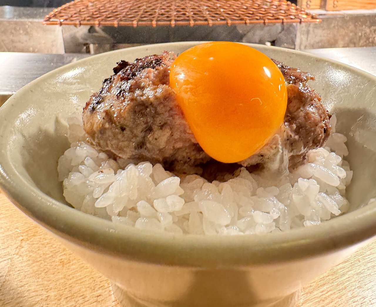 ごはんの上のハンバーグに卵黄をのせたところ