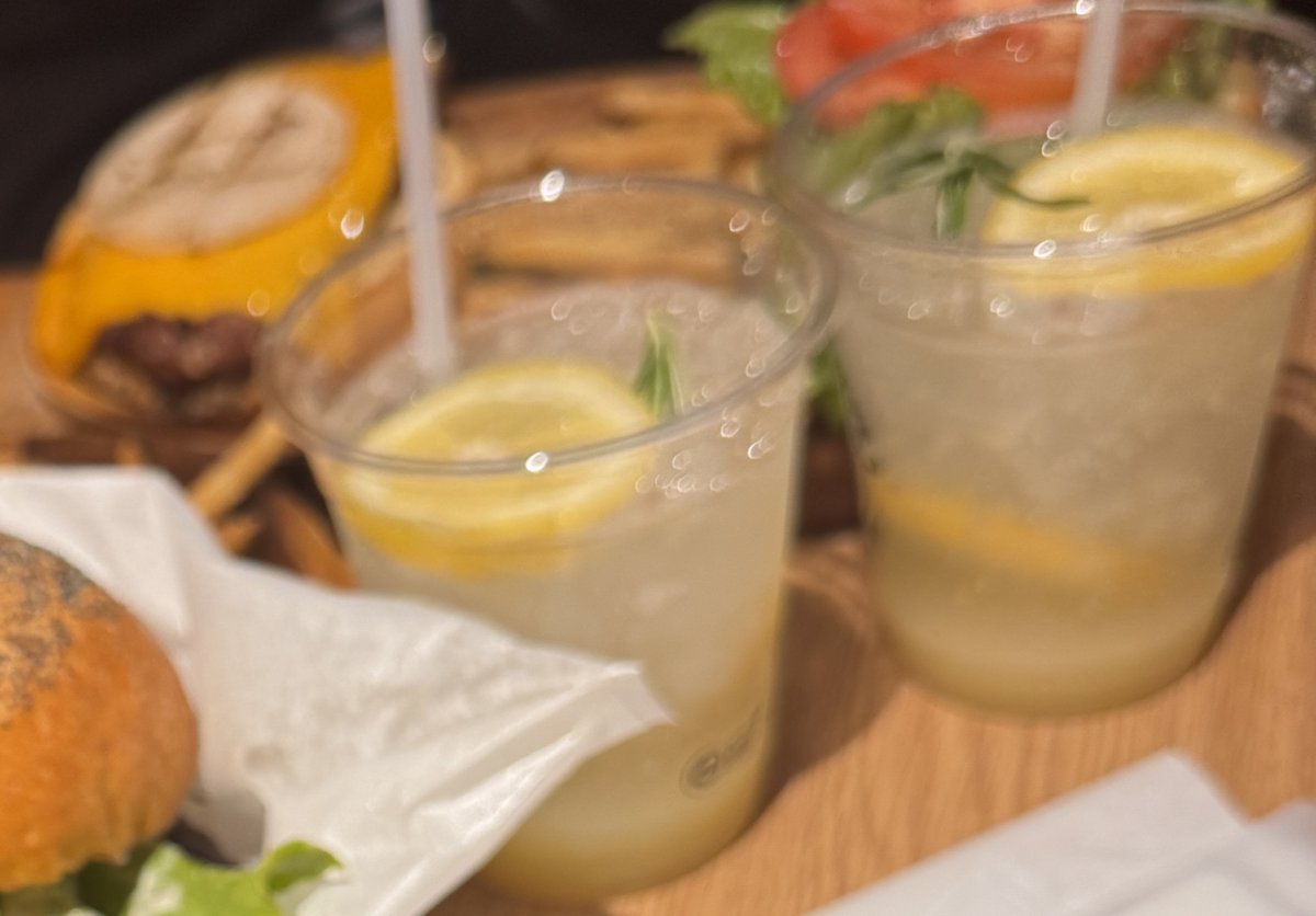 奥にチェダーチーズのハンバーガー、手前にレモンとローズマリーが入った飲み物が2つ