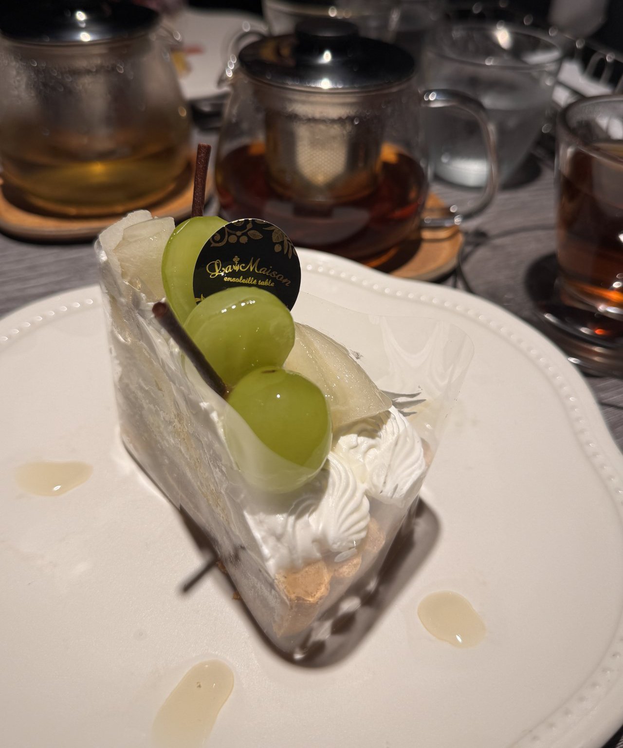 ケーキに立てた黒い丸いチョコの飾り。金色の文字でLa Maison ensoleillé tableと書いてある