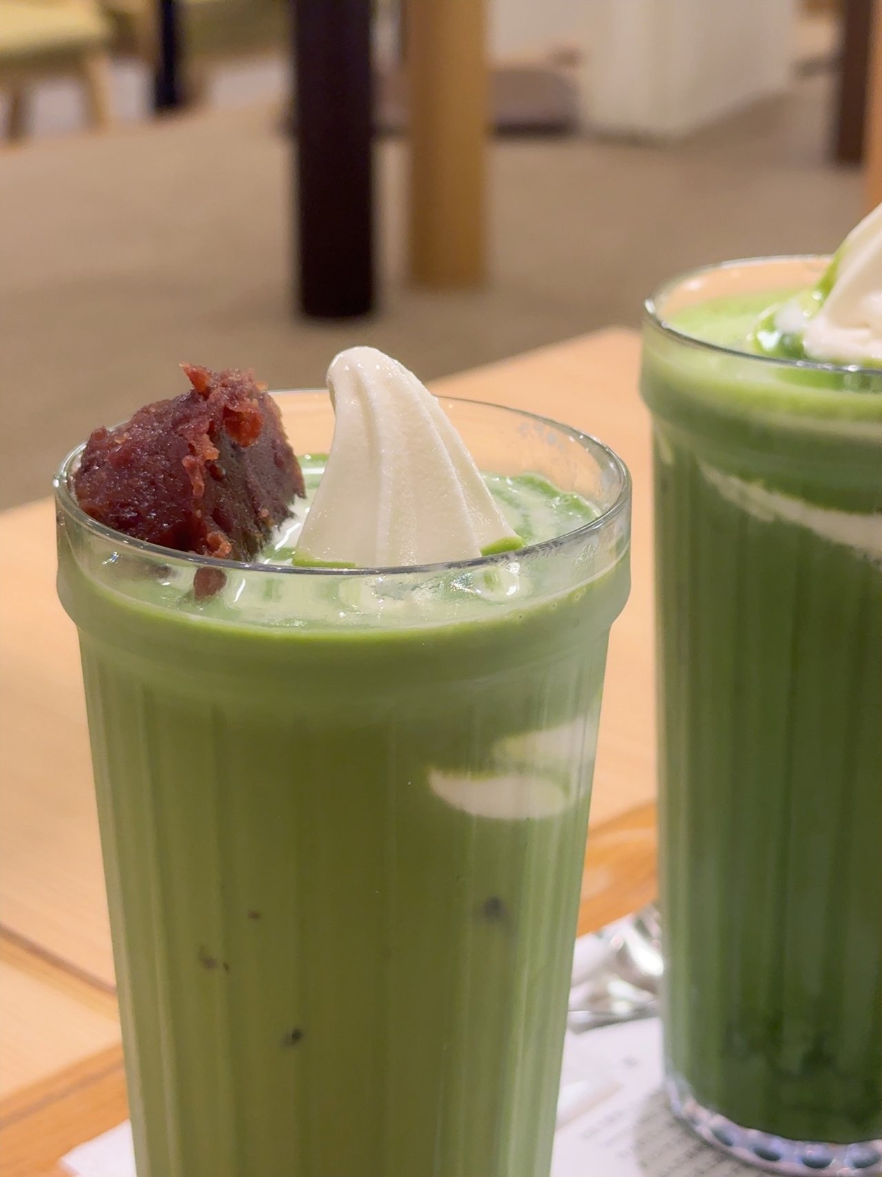 手前に粒あんとソフトクリームの抹茶ラテ、奥にソフトクリームの抹茶ラテが並んでいる
