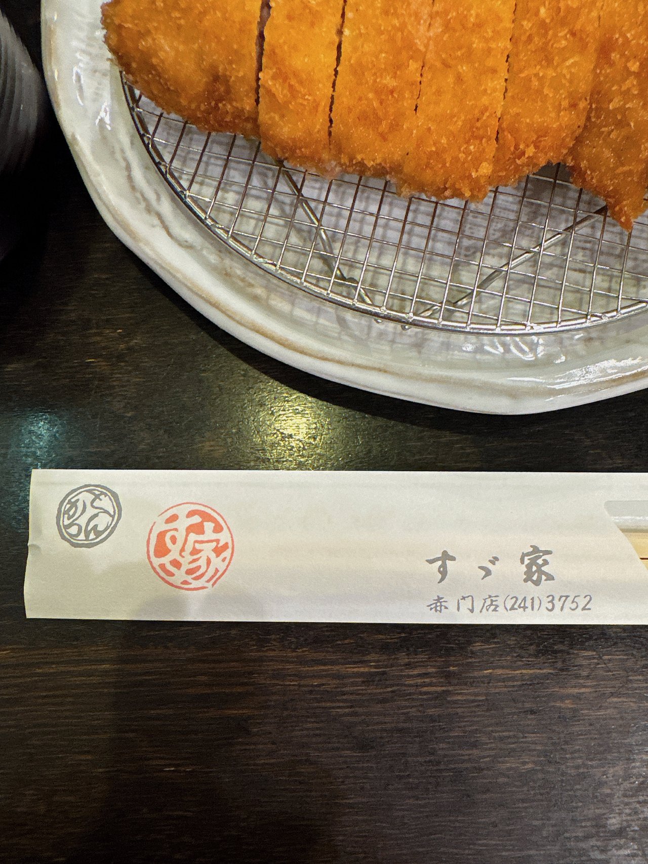 すゞ家 赤門店の箸袋。とんかつの丸い印と赤い印・店名と電話番号が入っている