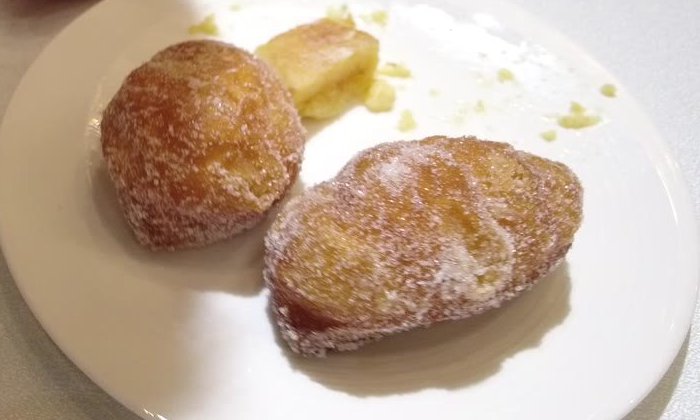 砂糖をまぶした揚げ菓子2個とプディングをのせた皿