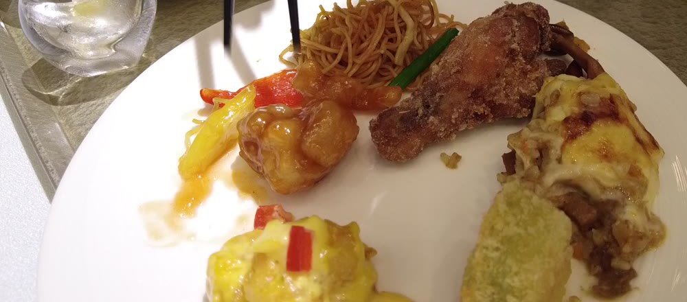 揚げ鶏・焼きそば・チーズ焼き・海老料理を盛り合わせた皿